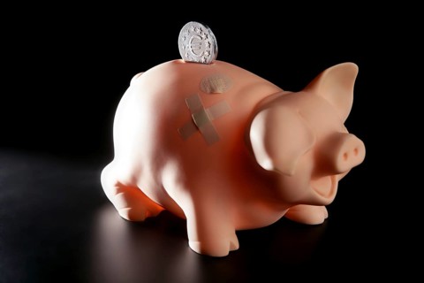 Saving money in crisis time, wounded piggy bank