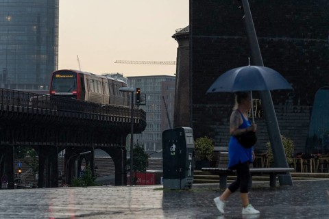 Symbolic picture weather, heavy rain in summer, thunderstorm, storm, tourist with umbrella on the
