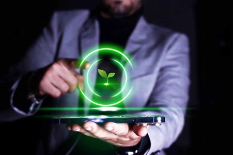 Businessman pointing to his cell phone with an icon of growing and protecting plants and the