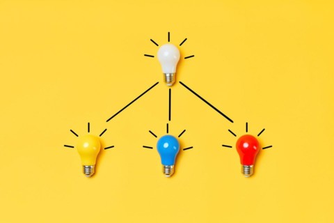 Creative layout with multicolored lightbulbs on yellow background. Idea symbol, business