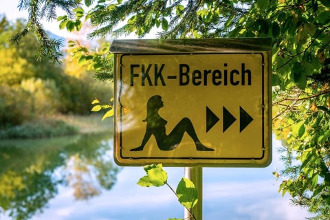 German sign board leading the way to the nude swimming area (FKK area) at the beach of lake Bibi