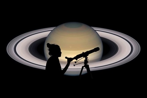 Girl looking at the stars with telescope. Saturn planet, isolated on black. Elements of this image