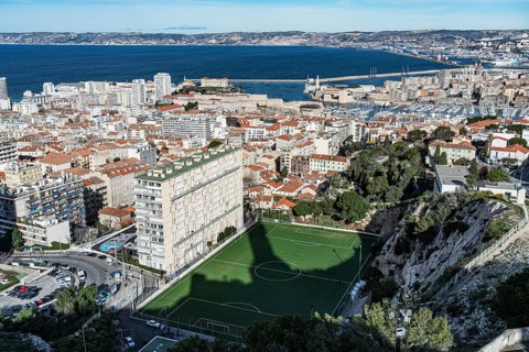 View of football pitch, houses, old harbour and Mediterranean Sea, Marseille, France, Europe