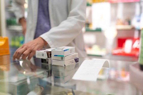 Medications stacked on a pharmacy counter, ready to be sold. Represents a typical scene in the
