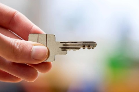 Holding a house key in the hand: New home and property