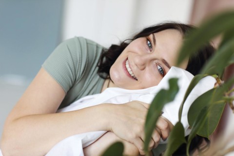 Happy cheerful young woman with big blue eyes resting relaxing at home on weekend, enjoying leisure