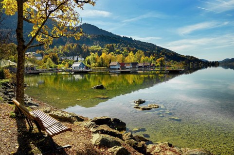 Lakeside path and boathouses on the autumnal large Alpsee lake near Bühl, Immenstadt Im Allgäu,