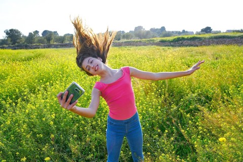 Teen girl selfie video photo in spring meadow moving hair