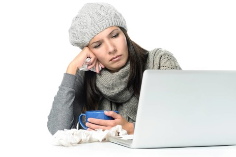 Close up Tired Sick Woman in Gray Winter Attire Working with Her Laptop While Having Cup of hot tea