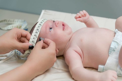 Pediatrician examining little baby in clinic