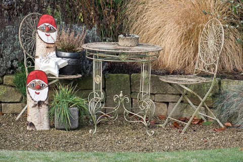 Iron garden furniture and Christmas gnome decorations on a gravel path, borken, North