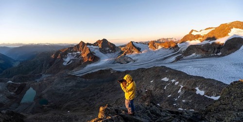 Mountaineers photographed, picturesque high mountain landscape at sunrise with alpenglow, glacier