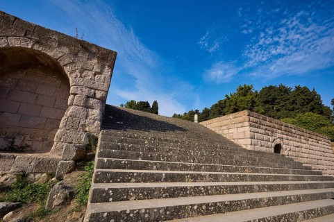 Stone staircase with ancient structures, surrounded by trees and clouds, open staircase to the