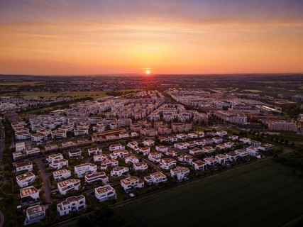 The sun rises behind the Riedberg district of Frankfurt. (Aerial photo with a drone), Germany,