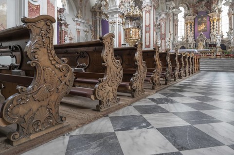 Artfully carved cheeks of the church pews in the collegiate basilica, Neustift St Margarethen,