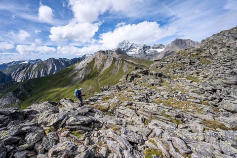 Mountaineer in boulder terrain, at the summit of Kastenegg, view of picturesque mountain landscape