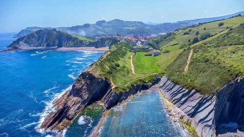 Aerial perspective captures the stunning beauty of zumaia's flysch cliffs meeting the vibrant blue
