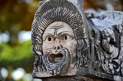 Ancient stone sculpture, stone carving of a mask, Roman theatre, ancient port city of Rome,