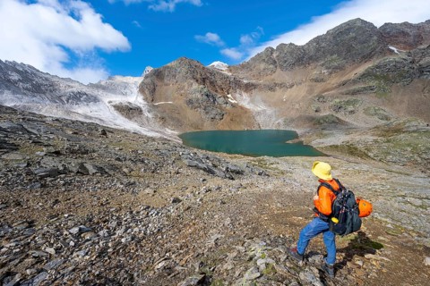 Mountaineer in front of mountain landscape with limestone rocks between granite mountains, mountain