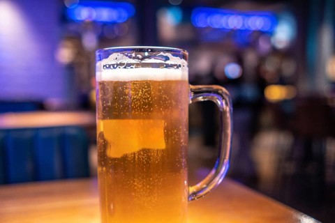 Cold beer waiting on the table in a lively london pub, inviting friends to enjoy a refreshing drink