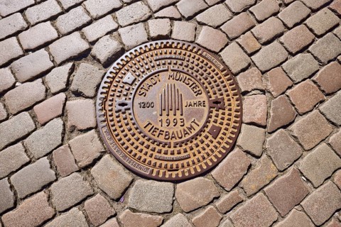 Manhole cover, city of Münster civil engineering, 1200 years 1993, cobblestones, Münster,