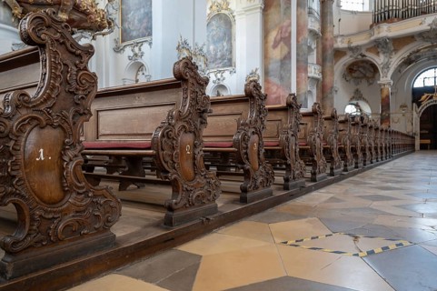 Decoratively carved cheeks of the lay pews in the baroque Basilica of St Alexander and St Theodore,