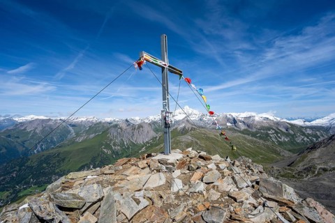 Böses Weibl summit with summit cross and colourful prayer flags, view of picturesque mountain