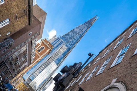 Low angle view of the shard skyscraper dominating the skyline above traditional brick buildings in