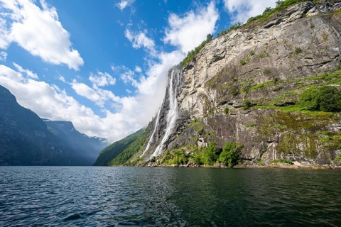 Geirangerfjord at the waterfall The Seven Sisters, tip of a red kayak in the fjord, atmospheric