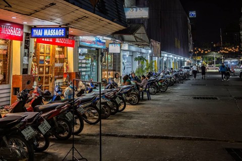 Massage parlor employees waiting for customers along a street in Chiang Rai, Thailand, Asia