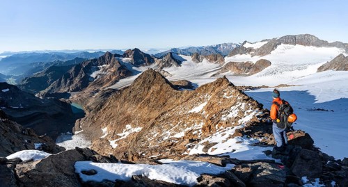 Mountaineer on a rocky ridge on the Wilder Freiger summit, behind him Signal summit and Becher