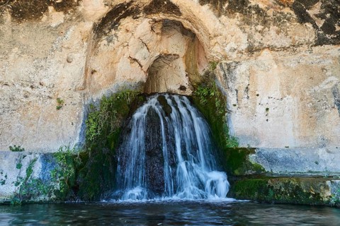 Nymph grotto, Small waterfall flowing from a rocky cave with moss growth, Neapolis Archaeological