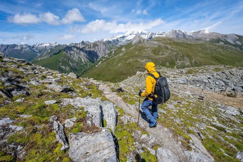 Mountaineers on a hiking trail, view of picturesque mountain landscape with snow-covered summit of