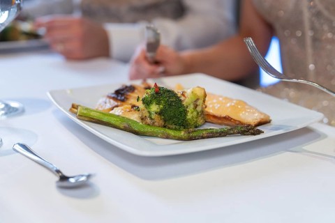 Gourmet plate with fish and broccoli is served on a laid table, event and wedding location Kloster