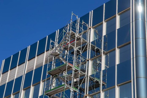 Steel scaffolding on the large glass façade of an office building