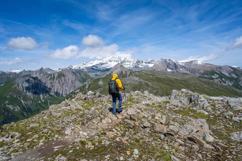 Mountaineers on a hiking trail, view of picturesque mountain landscape with snow-covered summit of