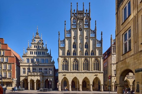 Historic town hall, facade, windows, arcades, gable, cobblestone street, pedestrians as secondary