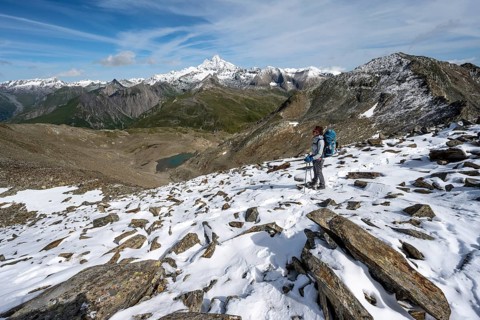 Mountaineer in boulder terrain with fresh snow in summer, ascent to the summit Böses Weibl, view of