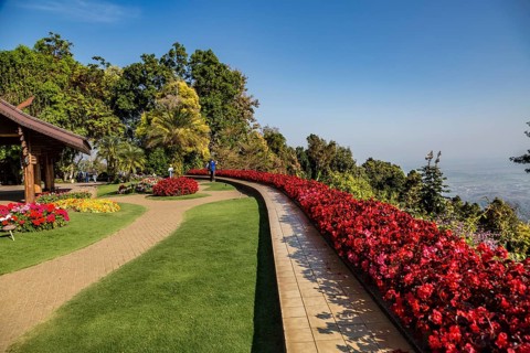 Colorful lush flower gardens line the perimeter of the mountain top Doi Tung Royal Villa lawn with