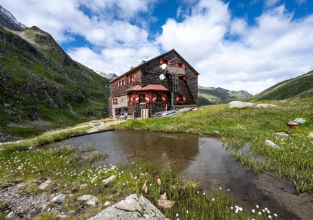 Elberfelderhütte mountain hut with small lake and cotton grass, in the upper Gössnitz valley,