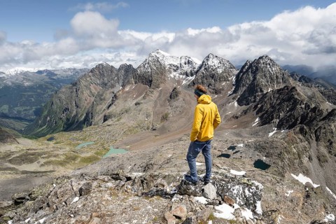 Mountaineer in rocky mountain landscape, at the summit of Keeskopf, behind summit of Petzeck, Hoher
