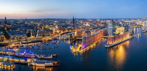 Panorama aerial view of the Elbphilharmonie at blue hour with illuminated windows and view over