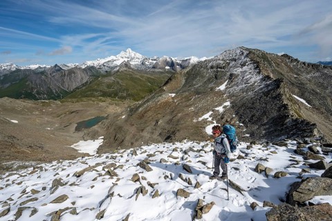 Mountaineer in boulder terrain with fresh snow in summer, ascent to the summit Böses Weibl, view of