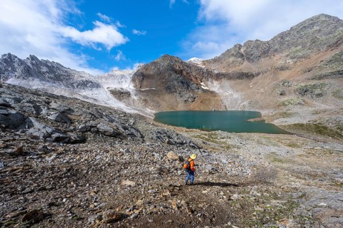 Mountaineer on a hiking trail, mountain landscape with limestone rocks between granite mountains,