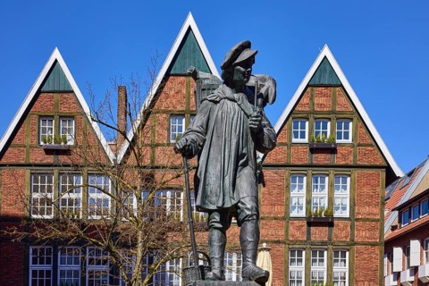 Kiepenkerl monument, bronze sculpture, brick architecture, facade, window, blue cloudless sky,