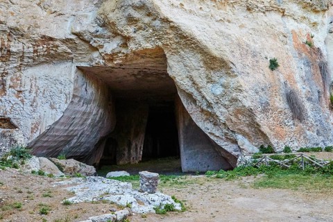 Rope grotto, Large opening to a cave in a rocky landscape surrounded by grass, Neapolis