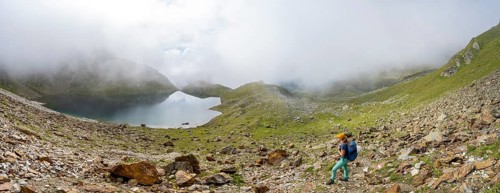 Mountaineer on a hiking trail, cloudy mountain landscape with mountain lake, Middle Moarer Egetsee,