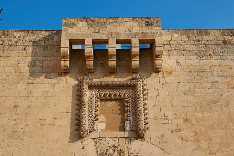Detailed view of an old wall with architectural decorations under a blue sky, Ortigia Island, Isola