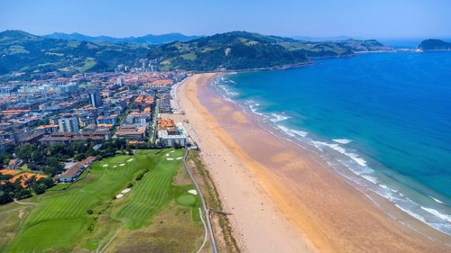Aerial view of zarautz, gipuzkoa, showcasing the golden sands, turquoise waters, and green hills of