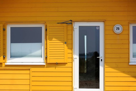 Yellow bungalow, holiday home, wooden house, facade detail with glass door and window, Insel Düne,
